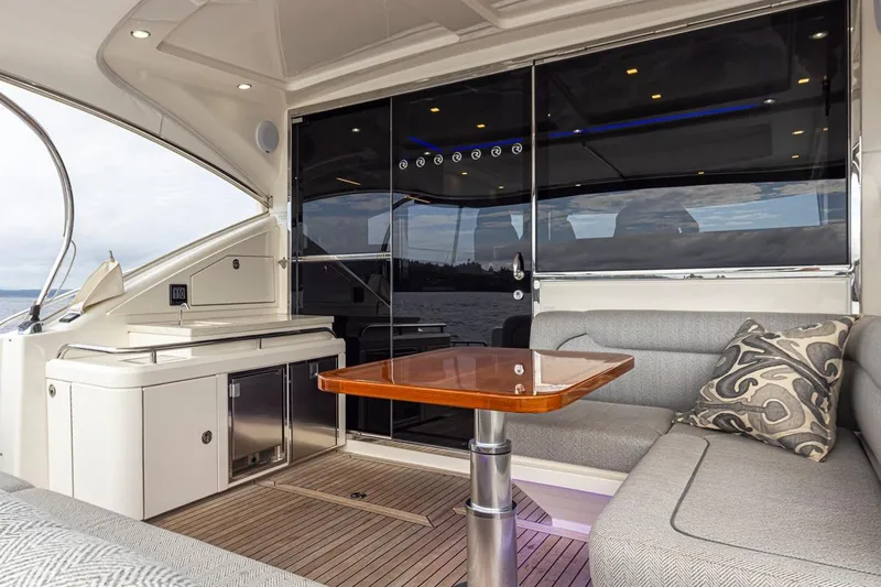 Lucky Dog Yacht Photos Pics Luxurious interior of 2018 Riviera 4800 Sport Yacht with elegant seating and wooden table.