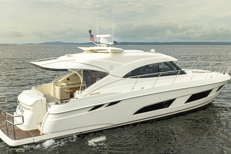 Lucky Dog Yacht Photos Pics 2018 Riviera 4800 Sport Yacht cruising on open water, showcasing sleek design and luxury features.