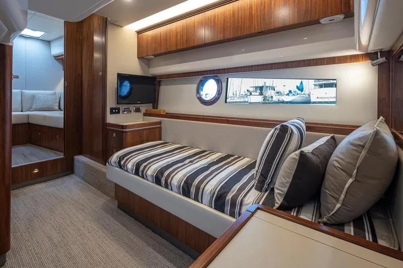 Lucky Dog Yacht Photos Pics Luxurious interior of 2018 Riviera 4800 Sport Yacht with striped bedding and wood accents.