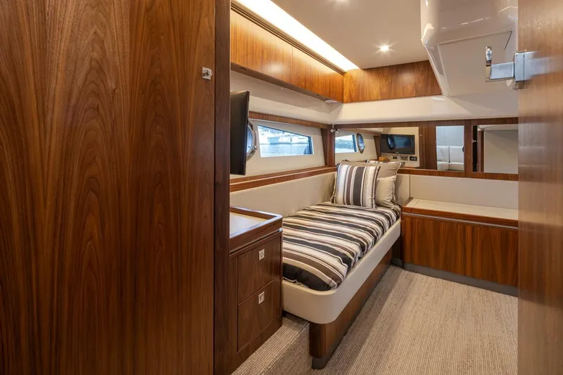 Lucky Dog Yacht Photos Pics Luxurious 2018 Riviera 4800 Sport Yacht cabin with wood finish and striped bedding.