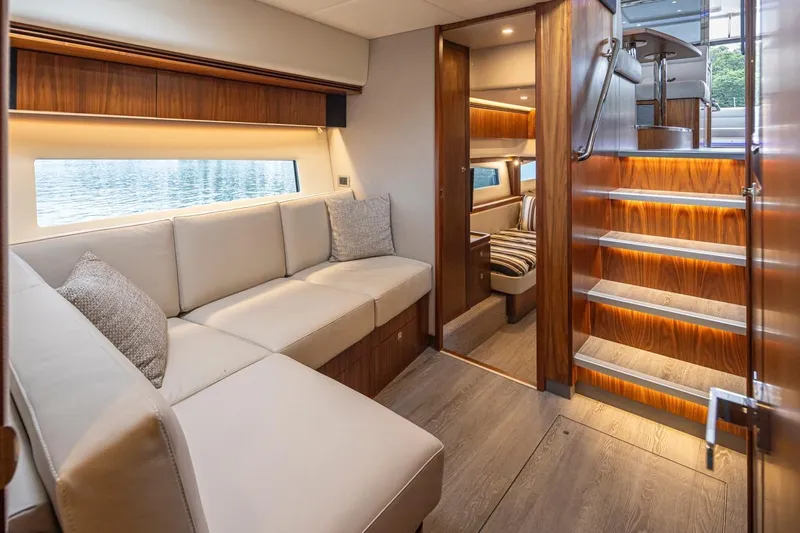 Lucky Dog Yacht Photos Pics Luxurious interior of 2018 Riviera 4800 Sport Yacht with elegant wood finishes and cozy seating.
