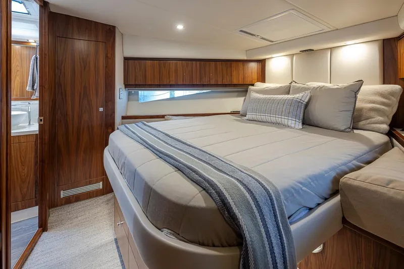 Lucky Dog Yacht Photos Pics Luxurious bedroom interior of 2018 Riviera 4800 Sport Yacht with elegant wood finishes.
