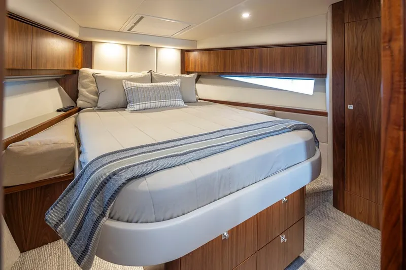 Lucky Dog Yacht Photos Pics Luxurious bedroom interior of 2018 Riviera 4800 Sport Yacht with elegant wood finishes.