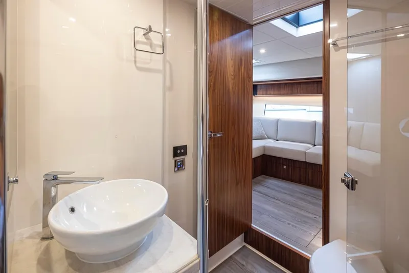 Lucky Dog Yacht Photos Pics Luxurious bathroom interior of 2018 Riviera 4800 Sport Yacht with modern sink and wood accents.