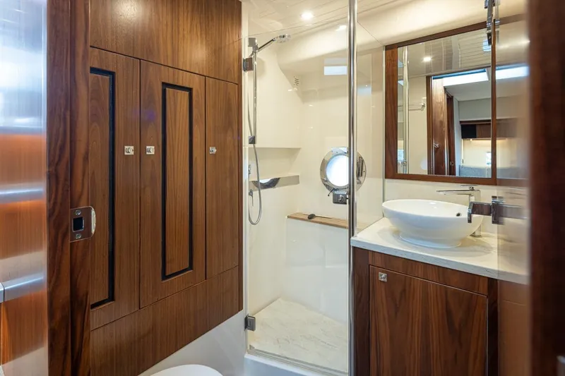 Lucky Dog Yacht Photos Pics Luxurious bathroom in 2018 Riviera 4800 Sport Yacht with wood accents and modern fixtures.