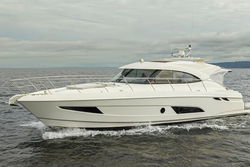 Lucky Dog Yacht Photos Pics 2018 Riviera 4800 Sport Yacht cruising on open water under cloudy skies.