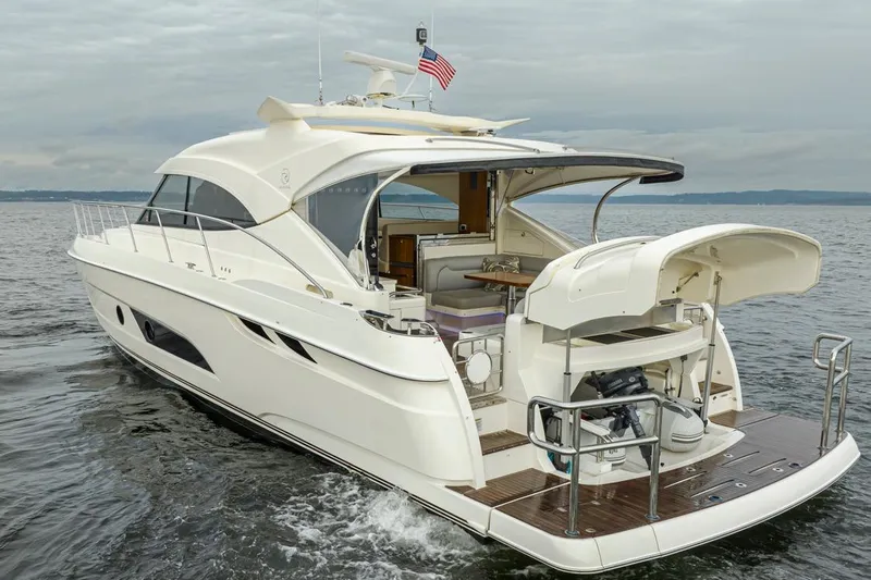 Lucky Dog Yacht Photos Pics 2018 Riviera 4800 Sport Yacht cruising on open water, showcasing sleek design and luxury features.