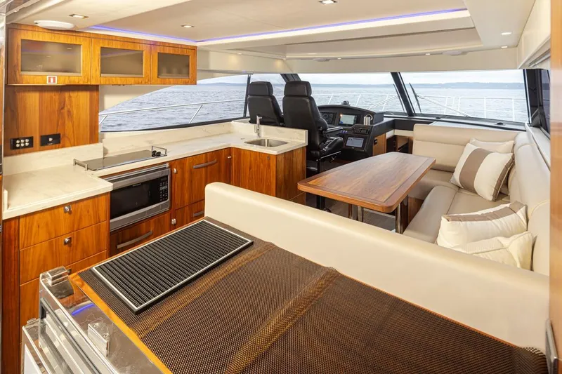 Lucky Dog Yacht Photos Pics Luxurious interior of 2018 Riviera 4800 Sport Yacht with modern kitchen and seating area.