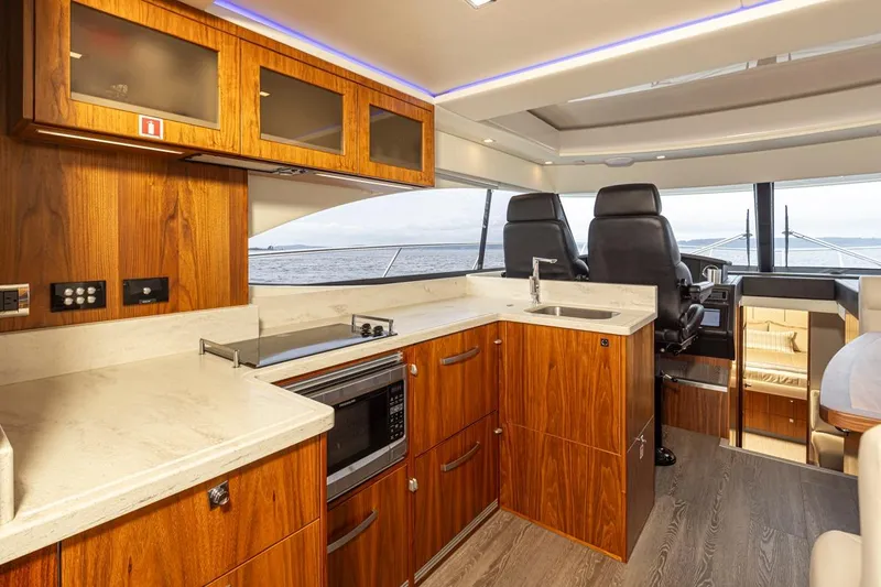 Lucky Dog Yacht Photos Pics Luxurious interior of 2018 Riviera 4800 Sport Yacht with modern kitchen and seating area.