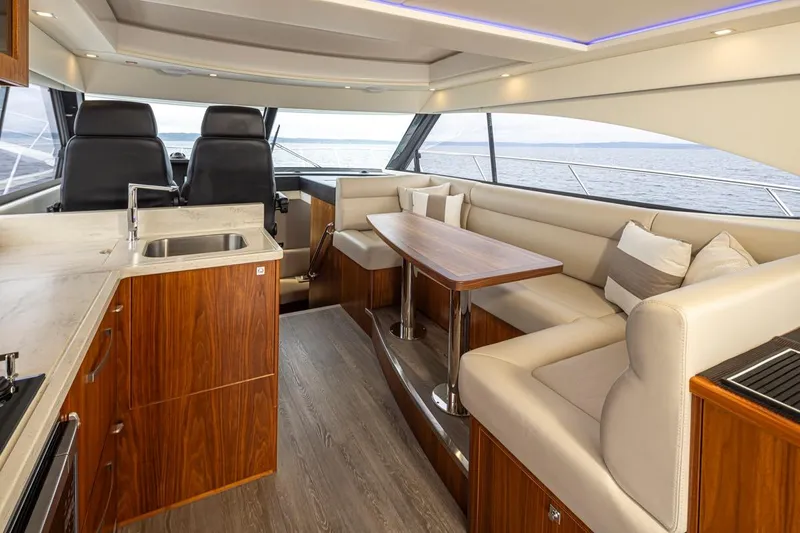Lucky Dog Yacht Photos Pics Luxurious interior of 2018 Riviera 4800 Sport Yacht with elegant seating and modern kitchen.