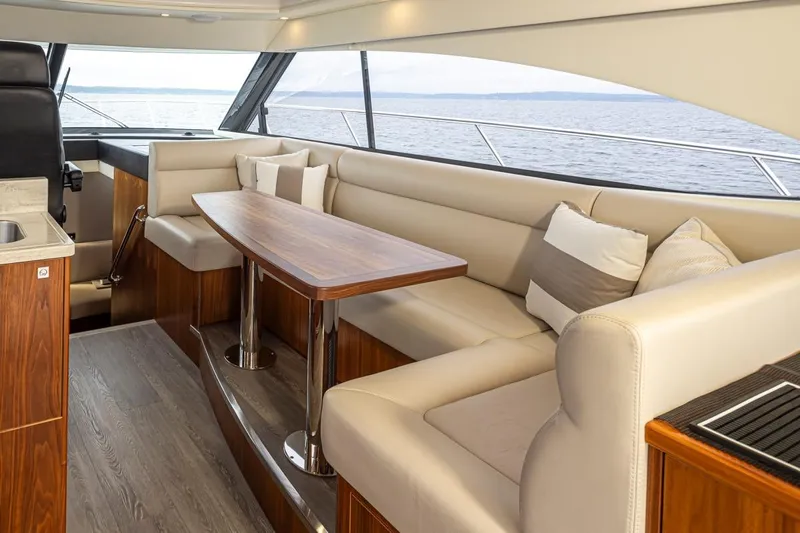 Lucky Dog Yacht Photos Pics Luxurious interior of 2018 Riviera 4800 Sport Yacht with elegant seating and ocean view.
