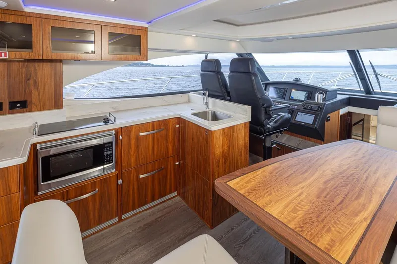 Lucky Dog Yacht Photos Pics Luxurious interior of 2018 Riviera 4800 Sport Yacht with modern kitchen and helm.