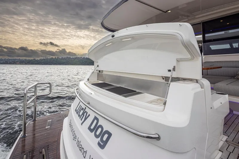 Lucky Dog Yacht Photos Pics 2018 Riviera 4800 Sport Yacht on water, open storage, sunset view.