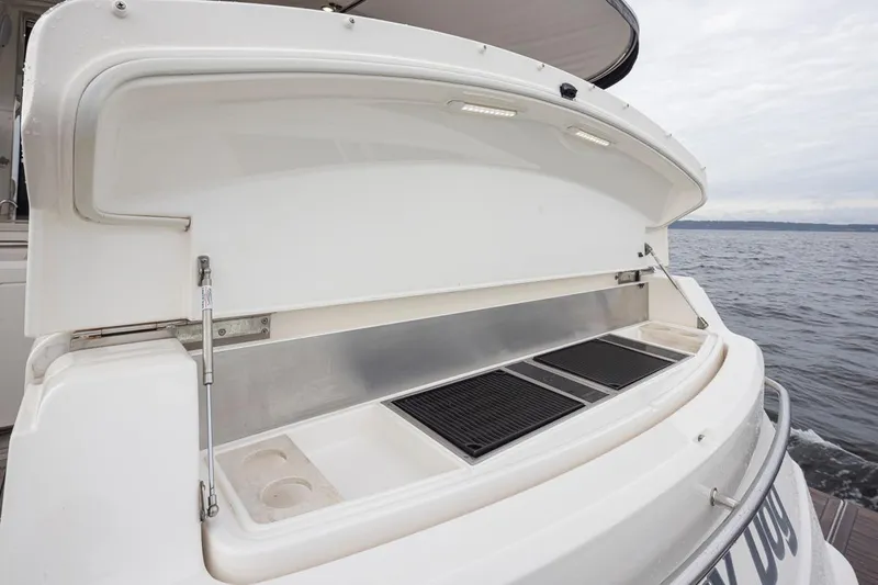 Lucky Dog Yacht Photos Pics 2018 Riviera 4800 Sport Yacht with open rear storage compartment by the sea.