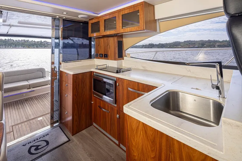 Lucky Dog Yacht Photos Pics Luxurious interior of 2018 Riviera 4800 Sport Yacht with modern kitchen and scenic water view.
