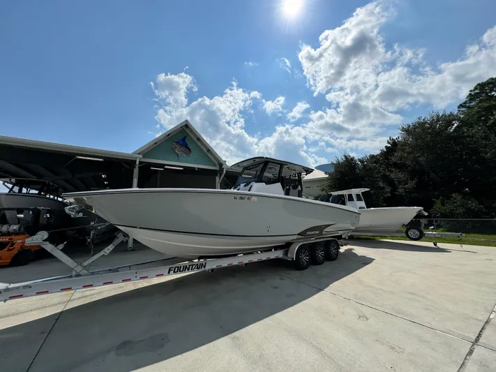  Yacht Photos Pics 2024 Fountain 32 NX boat on trailer under sunny sky.
