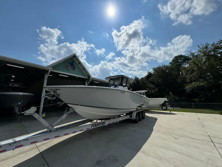  Yacht Photos Pics 2024 Fountain 32 NX boat on trailer under sunny sky.