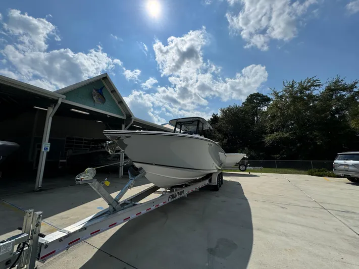  Yacht Photos Pics 2024 Fountain 32 NX boat on trailer under sunny sky.