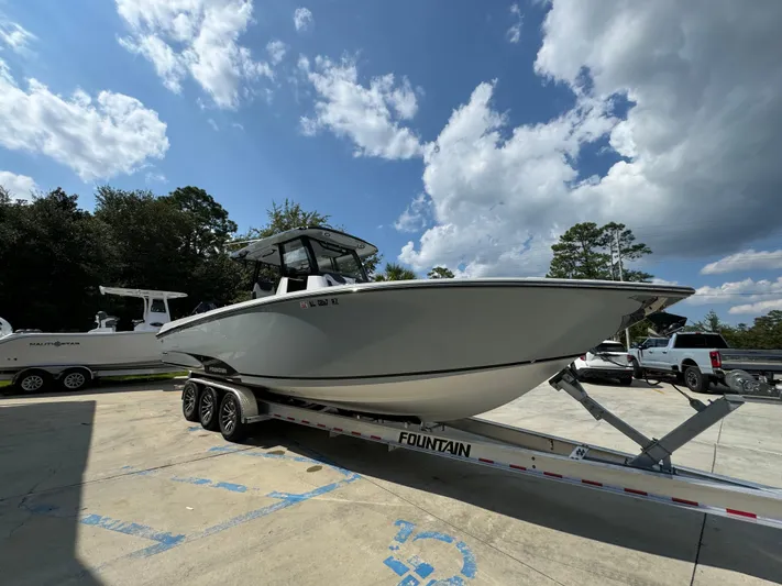  Yacht Photos Pics 2024 Fountain 32 NX boat on trailer under a partly cloudy sky.