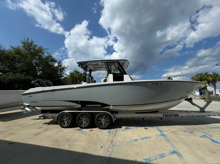  Yacht Photos Pics 2024 Fountain 32 NX boat on trailer under a partly cloudy sky.