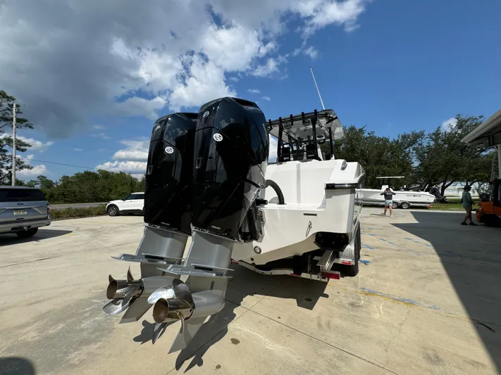  Yacht Photos Pics 2024 Fountain 32 NX boat with dual outboard motors in a sunny outdoor setting.