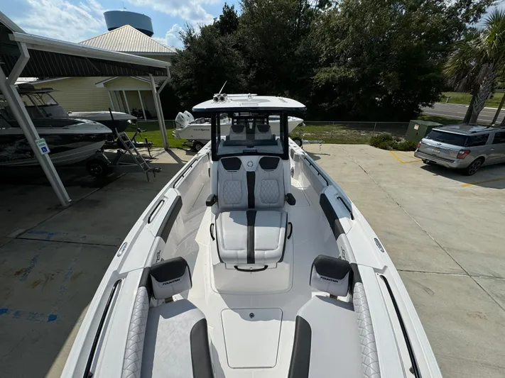  Yacht Photos Pics 2024 Fountain 32 NX boat with sleek design, docked outdoors.