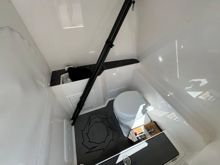  Yacht Photos Pics 2024 Fountain 32 NX boat interior with toilet and storage area.
