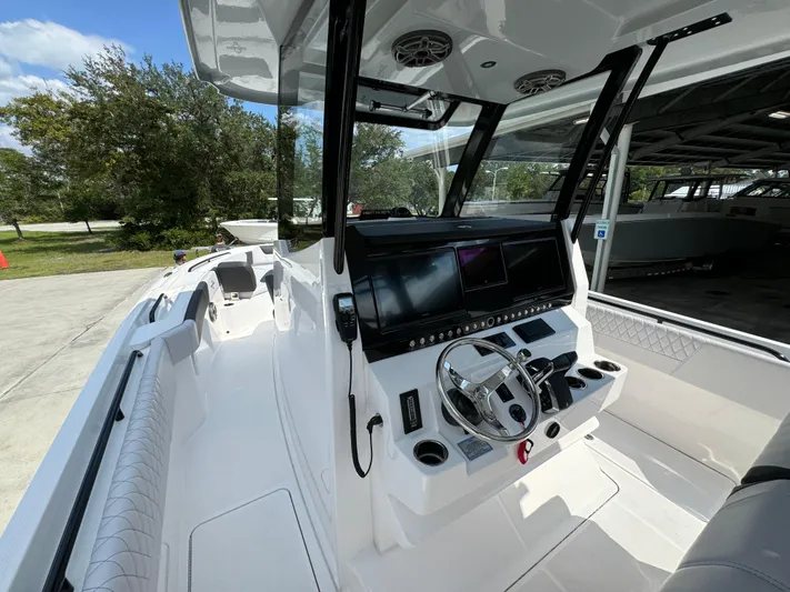  Yacht Photos Pics 2024 Fountain 32 NX boat interior with modern dashboard and steering wheel.