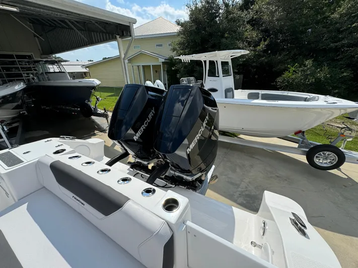  Yacht Photos Pics 2024 Fountain 32 NX boat with dual Mercury engines in a driveway.