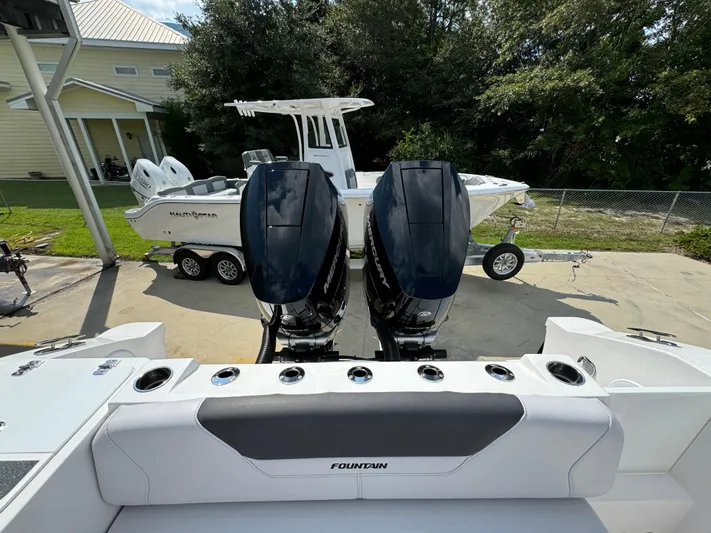  Yacht Photos Pics 2024 Fountain 32 NX boat with dual outboard engines, parked on a trailer.