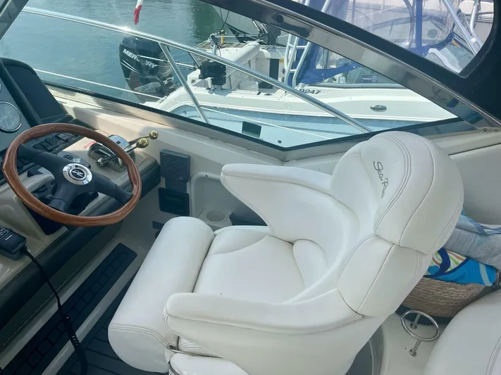  Yacht Photos Pics 2006 Sea Ray 44 Sundancer helm with white captain's chair and wooden steering wheel.