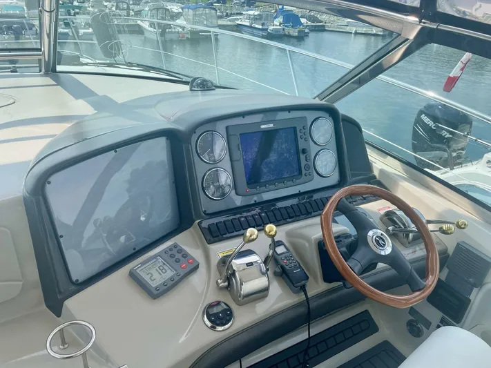  Yacht Photos Pics Helm of 2006 Sea Ray 44 Sundancer with navigation equipment and wooden steering wheel.