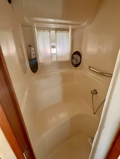  Yacht Photos Pics 2006 Sea Ray 44 Sundancer yacht bathroom with shower, white interior, and chrome fixtures.