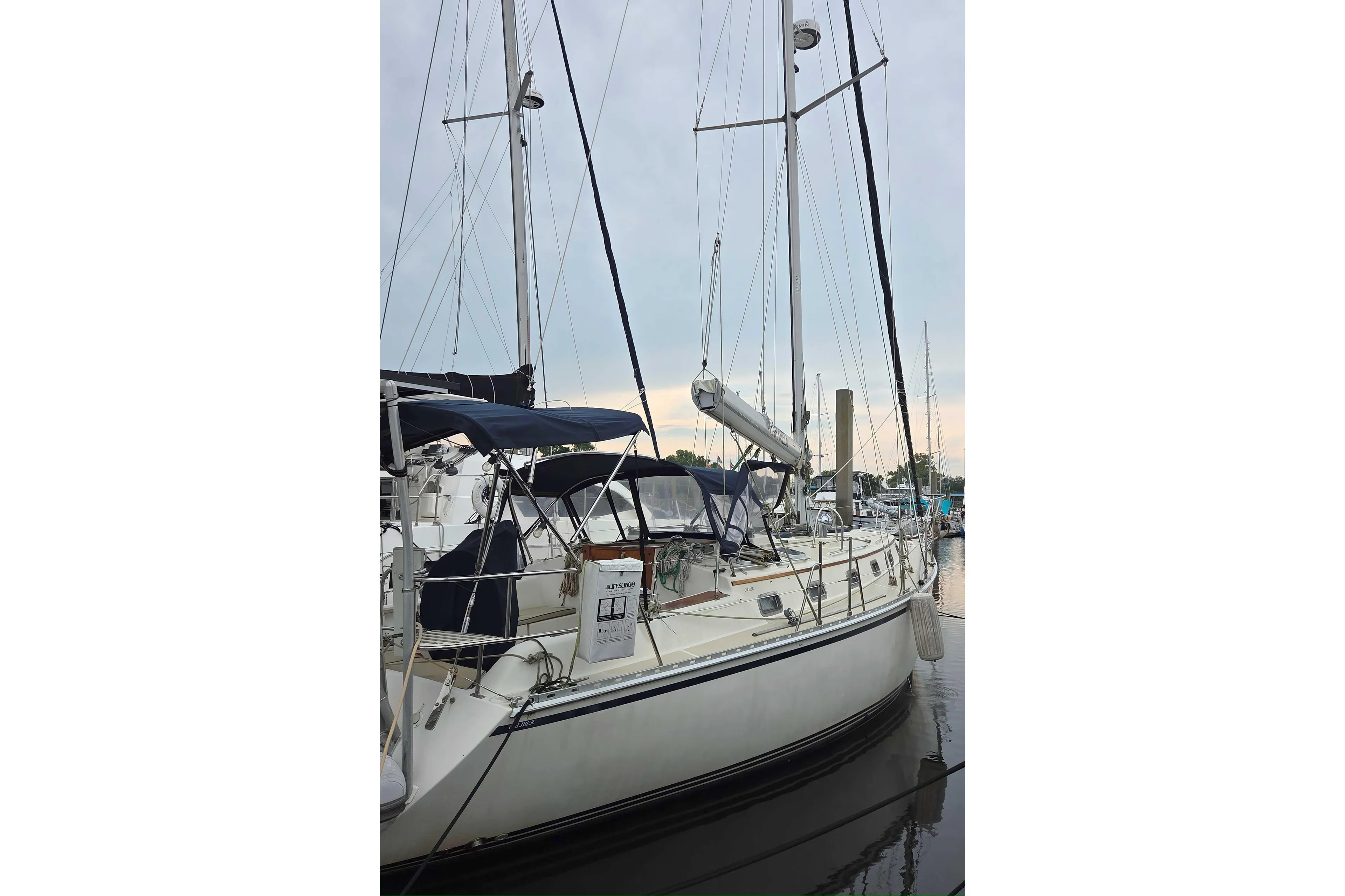 2001 Caliber 40LRC sailboat docked at marina, featuring sleek design and tall masts.