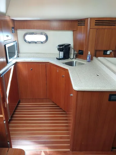 Hope Anne II Yacht Photos Pics 2003 Tiara Yachts 4400 Sovran galley with wood cabinetry, countertop, sink, and appliances.