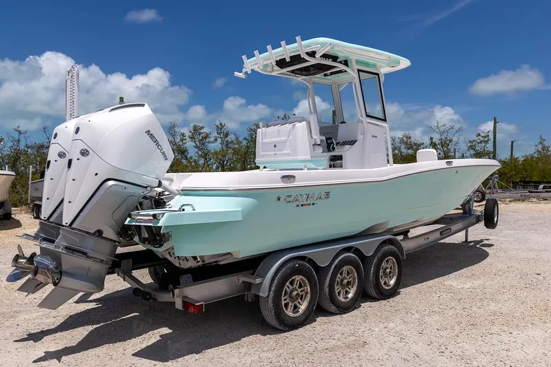  Yacht Photos Pics 2025 Caymas 281 HB boat on trailer, featuring dual outboard engines, under a clear blue sky.