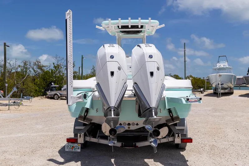  Yacht Photos Pics 2025 Caymas 281 HB boat with dual outboard engines, parked on a sunny day.