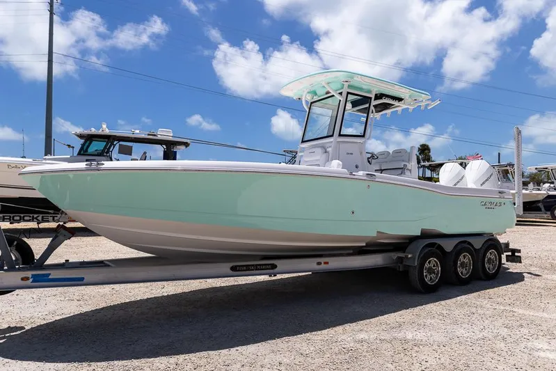  Yacht Photos Pics 2025 Caymas 281 HB boat on trailer under blue sky with clouds.