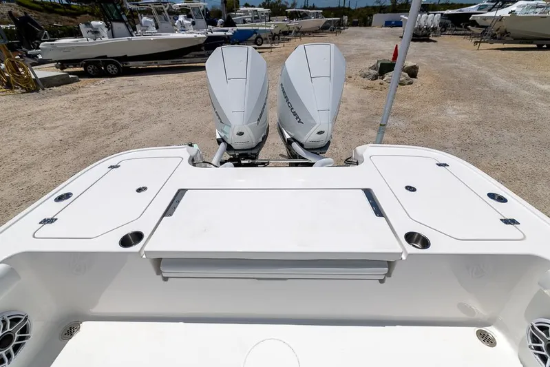  Yacht Photos Pics 2025 Caymas 281 HB boat with dual outboard motors, docked on a gravel lot.