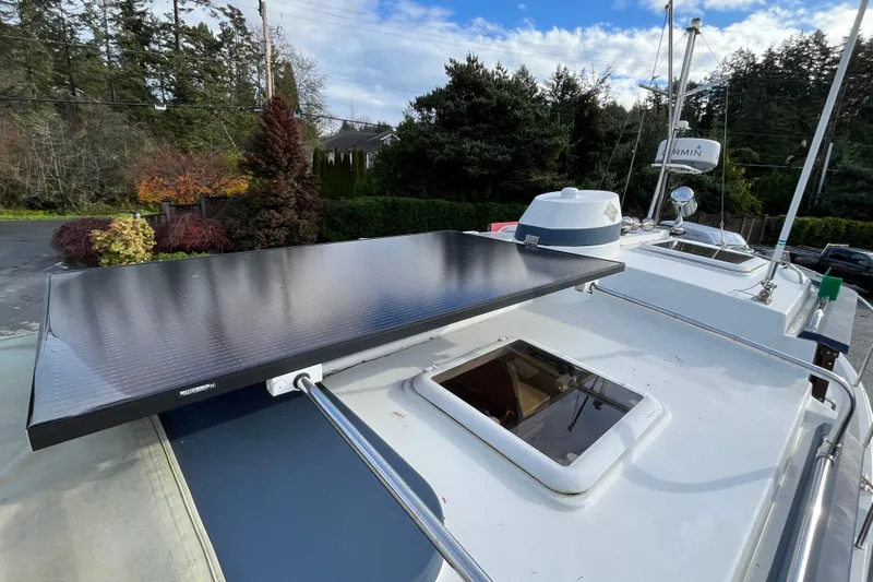 Rockin' Robin Yacht Photos Pics 2009 Ranger Tugs R-29 boat with solar panel on deck, surrounded by trees and clear sky.
