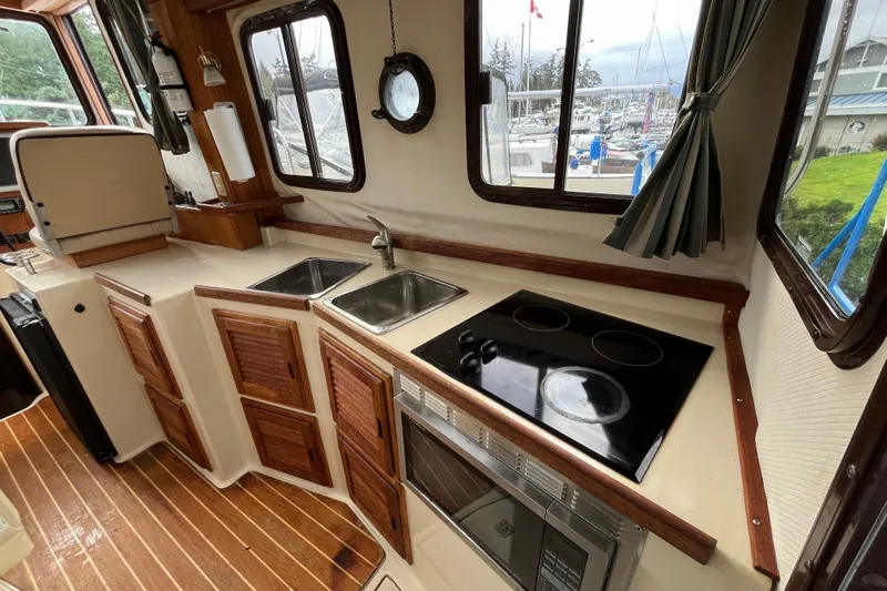 Rockin' Robin Yacht Photos Pics 2009 Ranger Tugs R-29 galley with dual sinks, stovetop, and microwave, overlooking marina.