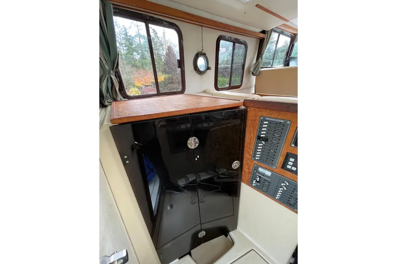 Rockin' Robin Yacht Photos Pics 2009 Ranger Tugs R-29 interior with control panel and wooden cabinetry.