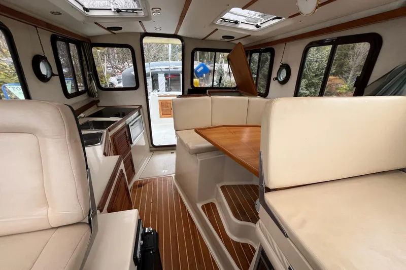 Rockin' Robin Yacht Photos Pics Interior of 2009 Ranger Tugs R-29 with seating, table, and kitchenette.