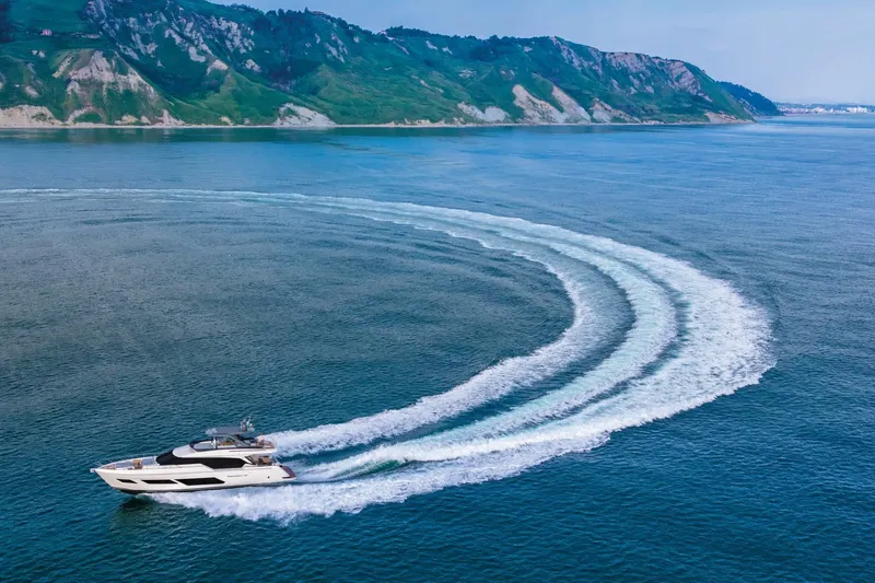  Yacht Photos Pics 2025 Ferretti Yachts 720 cruising in open sea near scenic coastline.