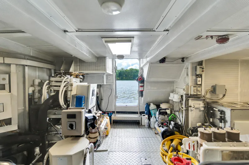 Marvelous Yacht Photos Pics Engine room of a 1999 Cheoy Lee 74 yacht with lake view through open door.