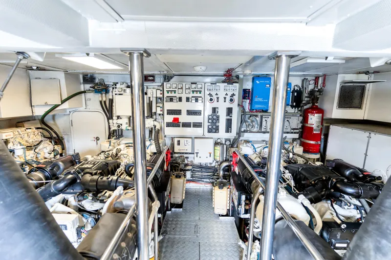 Marvelous Yacht Photos Pics Engine room of a 1999 Cheoy Lee 74 yacht, featuring dual engines and control panels.
