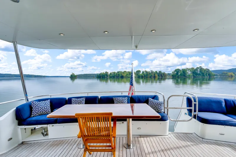 Marvelous Yacht Photos Pics Luxurious 1999 Cheoy Lee 74 yacht deck with seating, table, and scenic lake view.