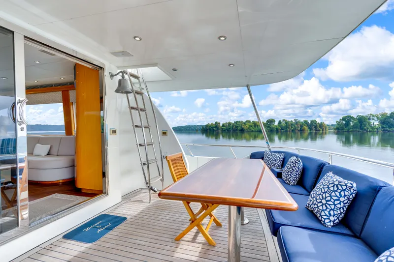 Marvelous Yacht Photos Pics Luxurious 1999 Cheoy Lee 74 yacht deck with seating, table, and scenic water view.