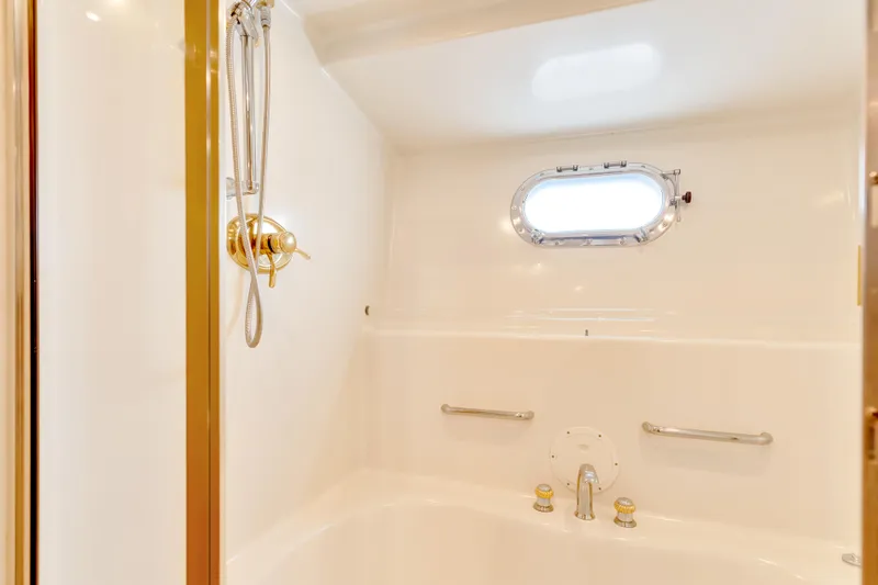 Marvelous Yacht Photos Pics Luxurious bathroom in 1999 Cheoy Lee 74 yacht with porthole and gold fixtures.