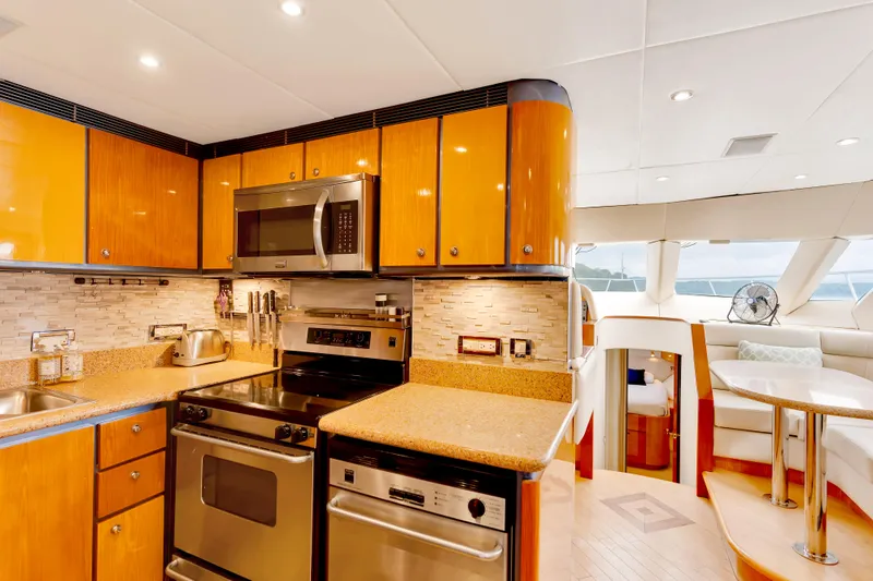 Marvelous Yacht Photos Pics Luxurious kitchen interior of 1999 Cheoy Lee 74 yacht with modern appliances and wood cabinetry.